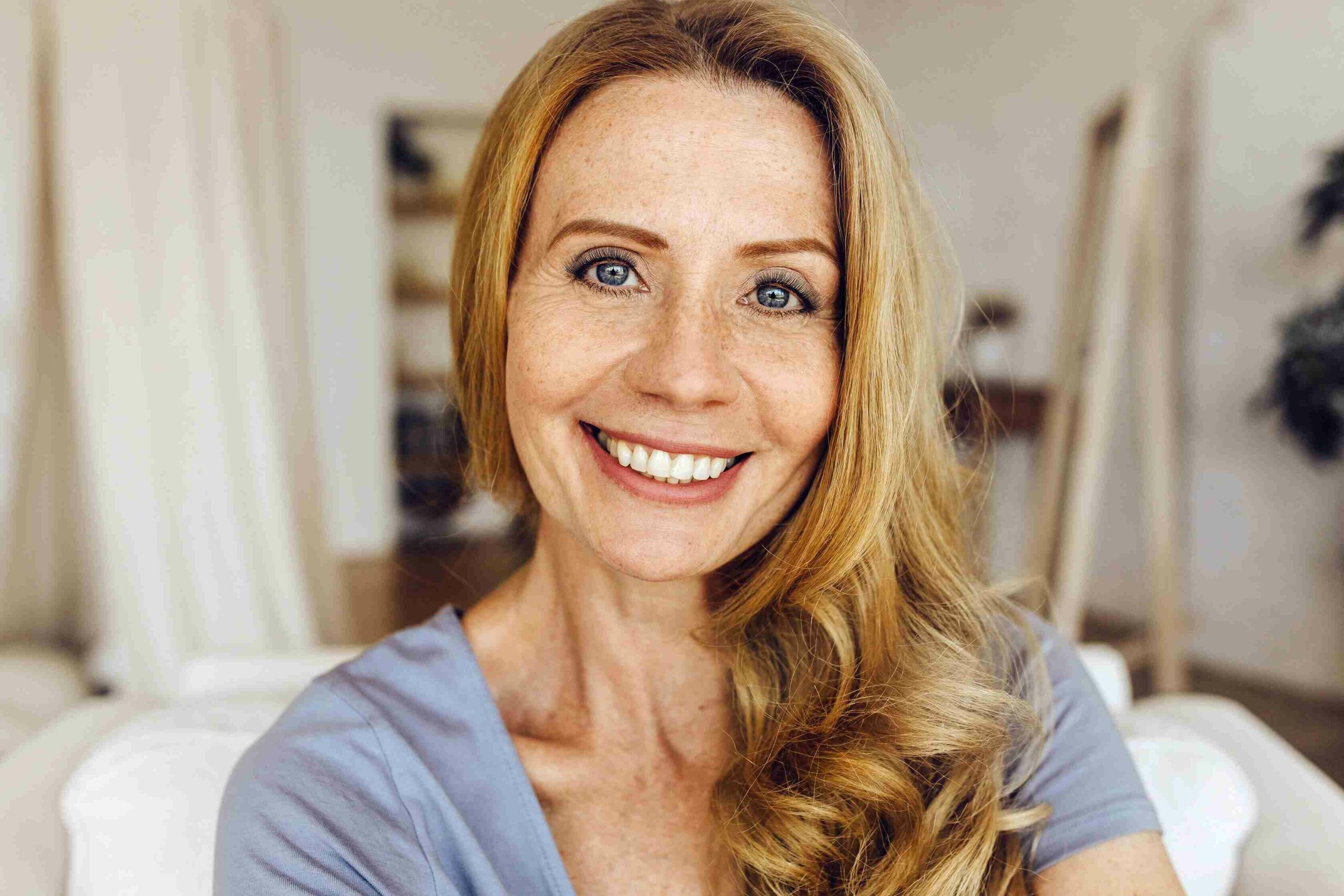 a closeup of a mature white woman smiling with lash extensions